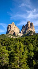 Scenic view of towering mountain peaks above a lush forest