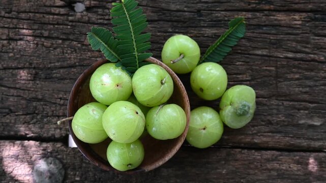Fresh Amla (Indian gooseberry, Phyllanthus emblica) fruits with leaf on wooden background. herbal medicine plant