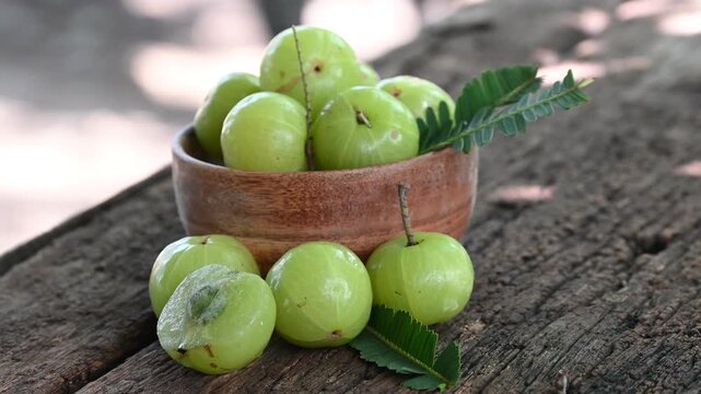 Fresh Amla (Indian gooseberry, Phyllanthus emblica) fruits with leaf on wooden background. herbal medicine plant