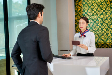 Air ground of airport staff checking face of businessman with his passport for prove to allow fly with airline service.