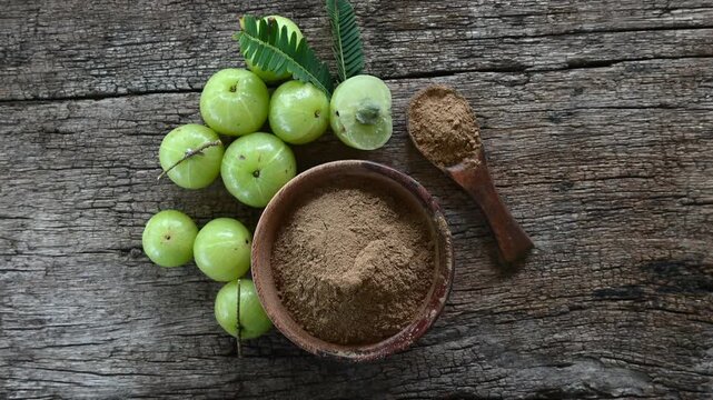 Fresh Amla (Indian gooseberry, Phyllanthus emblica) fruits with leaf on wooden background. herbal medicine plant