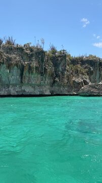 Boat excursion to Bahia De Las Aguilas, Pedernales, Dominican Republic. Crystal clear waters, amazing cliffs and rock in the sea. Touristic destination. Exclusive vacations.