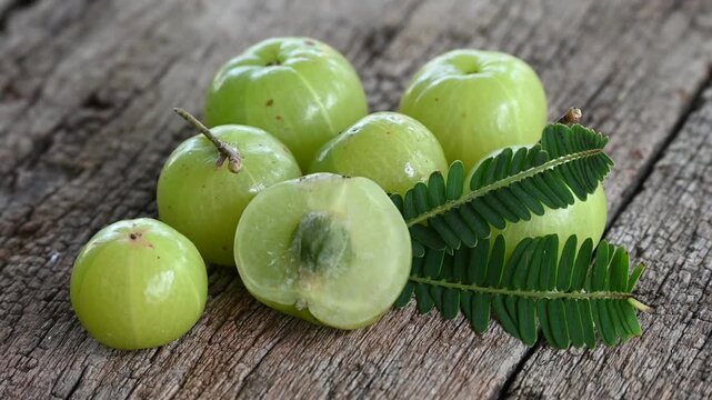 Fresh Amla (Indian gooseberry, Phyllanthus emblica) fruits with leaf on wooden background. herbal medicine plant