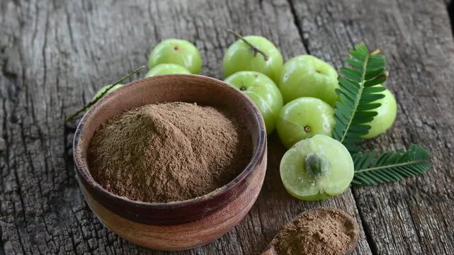 Fresh Amla (Indian gooseberry, Phyllanthus emblica) fruits with leaf on wooden background. herbal medicine plant