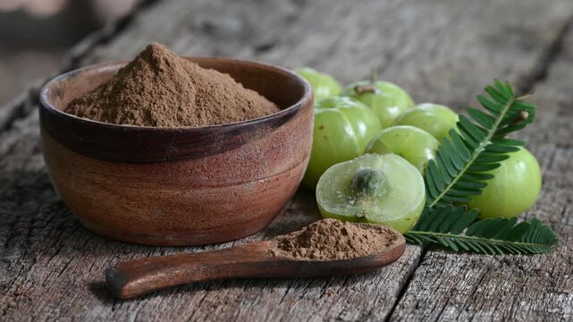 Fresh Amla (Indian gooseberry, Phyllanthus emblica) fruits with leaf on wooden background. herbal medicine plant