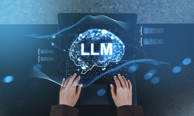 Hands typing on laptop with glowing LLM brain hologram symbolizing large language model technology...