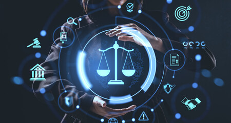 Futuristic justice concept with hologram of scales held by businessperson surrounded by legal icons...