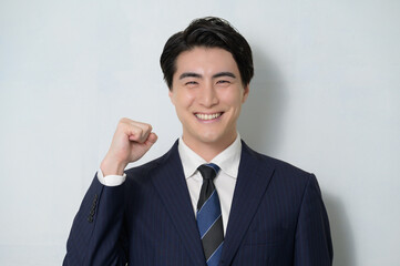 白は背景でガッツポーズをする日本人男性