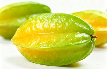 Vibrant close-up of a fresh tropical starfruit, also known as carambola, isolated on a clean white background
