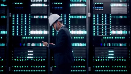 Side View of Asian Businessman Use Smartphone While Walking in Server Room Data Center - Powered by Adobe