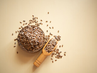 flax seeds in a wooden bowl on a beige background