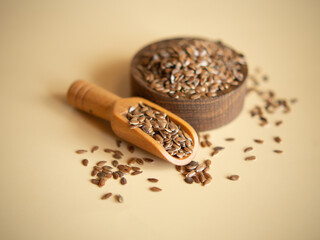 flax seeds in a wooden bowl on a beige background