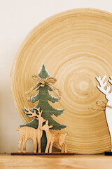 Decorative wooden figures of a tree and deer displayed on a light wooden surface
