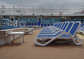 Sonnenliegen auf Luxus Kreuzfahrtschiff - Sun loungers and deck chairs on luxury cruiseship or cruise ship liner on outdoor sun pool deck