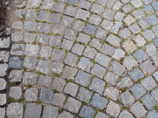 Close-up of traditional European cobblestone pavement with rounded grey stones and textured surface