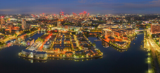 Night panorama of Salford Quays with Manchester skyline in view, glowing lights and reflections on...