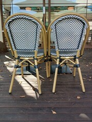 Striped accent wooden chairs and table on elegant cafe restaurant terrace
