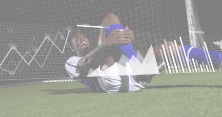 Male soccer player clutching knee activating sports data overlays tracking stress then raising arm - Powered by Adobe