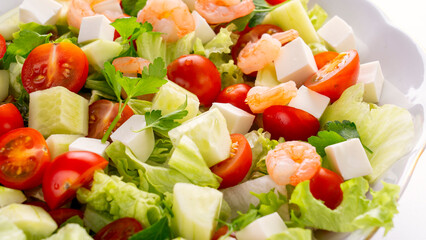 A vegetable salad with shrimp in the foreground. A nutritious dish featuring vibrant vegetables, feta cheese, and shrimp. High quality photo