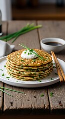 Stack of Savory Zucchini Pancakes with Sour Cream and Chives.