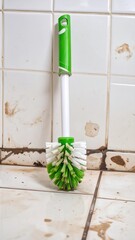Dirty cleaning brush on tiled wall