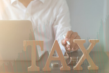 Tax, investment, business planning, and economic growth concept with businessman analyzing financial data and stacked coins for future strategy