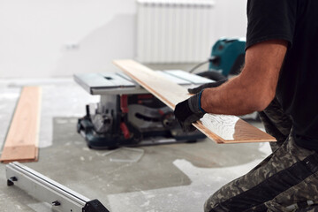 Professional handyman installing laminate flooring in a new apartment.