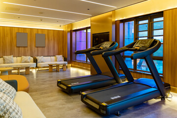 Modern gym interior with treadmills and comfortable seating area
