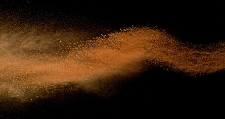 Flying orange clay dust in motion, isolated on black background. High-speed studio photo with dramatic particles explosion. Tennis-themed abstract powder movement.