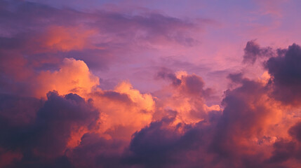 A view of a colorful sky filled with fluffy clouds illuminated by the setting sun light rays