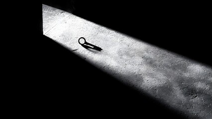 a single key lying on a rough concrete floor, illuminated by a narrow diagonal beam of light. Concept Single Key Still Life, Concrete Texture, Diagonal Beam Lighting, Minimalist Object Photography