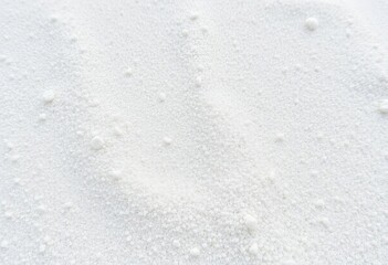 Fototapeta premium Fine, grainy white sand texture; close-up view showing subtle undulations, pattern, light