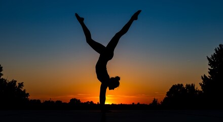Silhouette of a person doing a handstand against a sunset sky