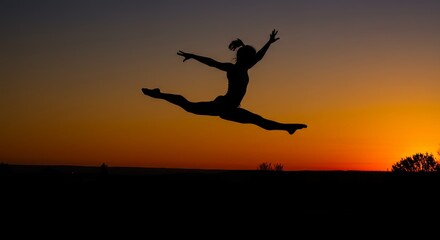 Silhouette of a person leaping against a sunset sky at dusk