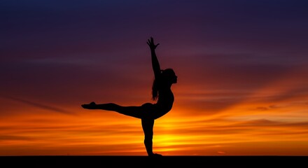 Silhouette of a person practicing yoga during sunset golden hour with vibrant sky background