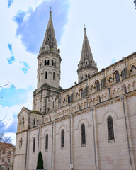 Fototapeta premium Historic church facade with pointed spires and cloudy sky