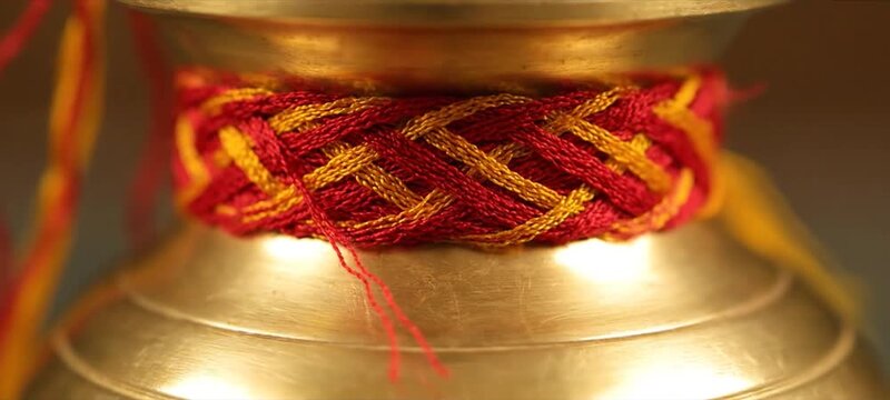 Golden Hindu Kalash Decorated with Sacred Mauli Thread for Puja.