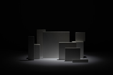 Minimalist composition of geometric white and grey blocks dramatically illuminated from below against a stark black background, highlighting abstract forms and strong contrasts.