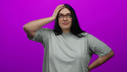 Young plus size woman with glasses poses confidently against a vibrant pink background wall...