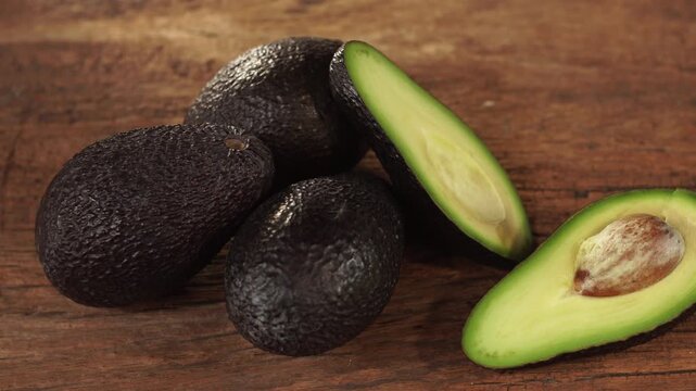 Ripe hass avocado fruit  on wooden background. Healthy fruits concept. Selective focus and free space for text.