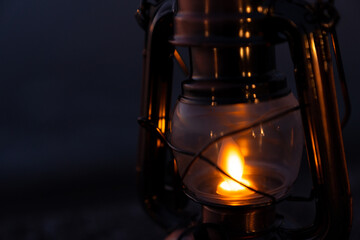 海辺に置かれたランタンの中でともる灯り
