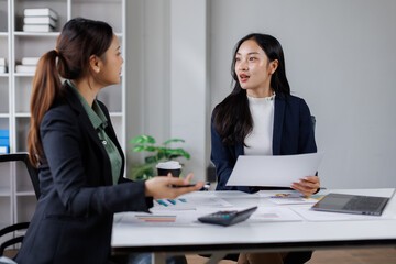 Fototapeta premium Team work asian women process. Marketing strategy brainstorming. Paperwork and digital in open space. Ideal for showcasing teamwork and strategic planning. 