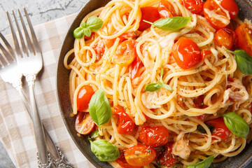 Margherita Spaghetti with cherry tomatoes, olive oil, butter, garlic, fresh basil, creamy mozzarella tossed closeup on the plate on the table. horizontal top view from above