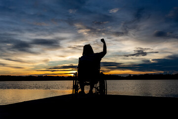 disabled woman in wheelchair watching sunset alone finding hope