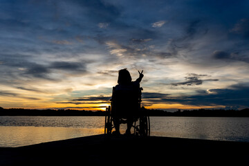 disabled woman in wheelchair watching sunset alone finding hope