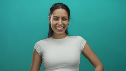Woman smiling and pointing upward against a vibrant green background, expressing happiness and confidence.