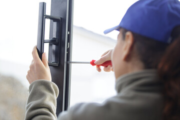 female worker screwing handle on a door