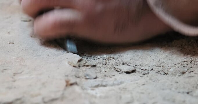 Close-up 10-bit 4K slow motion of an artisan's hands using a chisel and hammer for traditional stone carving in Southeastern Turkey. Showcasing ancient masonry and restoration techniques.
