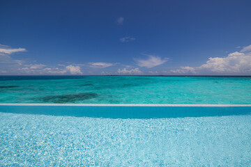 Luxury over water villa infinity pool stunning ocean lagoon sea view sunny summer vacation relax poolside resort paradise turquoise sea horizon palm trees blue sky tropical destination travel leisure