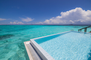 Luxury over water villa infinity pool stunning ocean lagoon sea view sunny summer vacation relax poolside resort paradise turquoise sea horizon palm trees blue sky tropical destination travel leisure